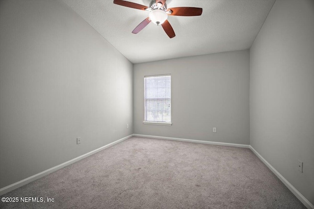 carpeted empty room with a textured ceiling, ceiling fan, baseboards, and lofted ceiling