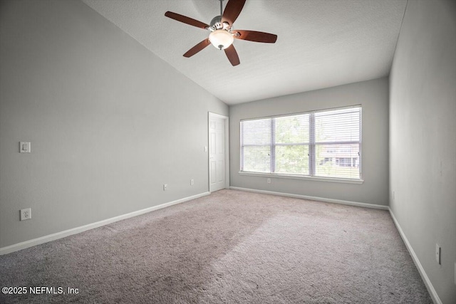 spare room with carpet floors, a ceiling fan, baseboards, and vaulted ceiling