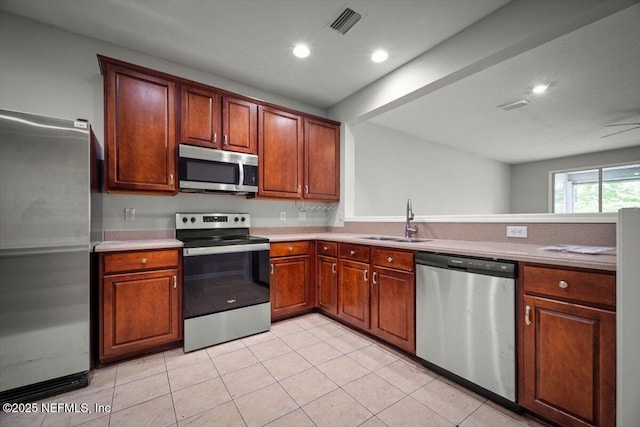 kitchen with visible vents, a sink, light tile patterned floors, and stainless steel appliances