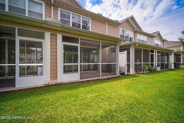 back of house featuring a yard and a sunroom