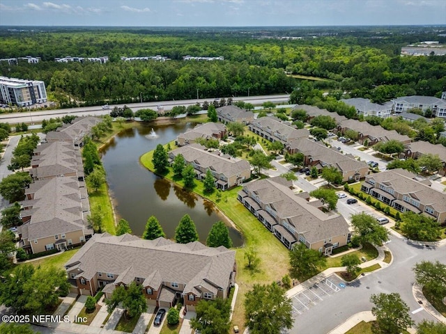 birds eye view of property with a water view, a view of trees, and a residential view