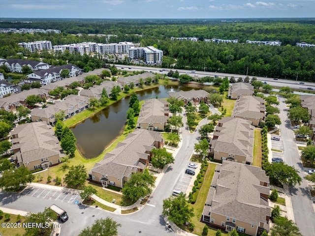 bird's eye view featuring a water view, a view of trees, and a residential view