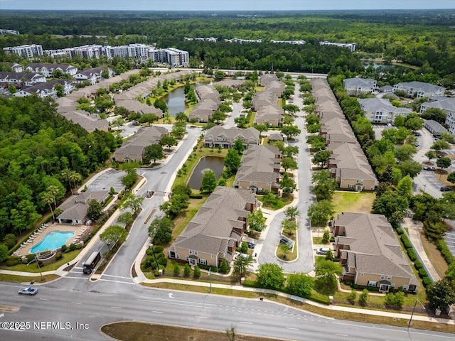 aerial view with a water view, a view of trees, and a residential view