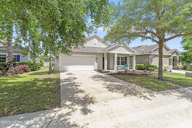 view of front of house with a front lawn, an attached garage, concrete driveway, and stucco siding