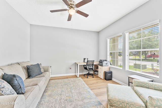 home office featuring a ceiling fan, baseboards, and light wood-style floors
