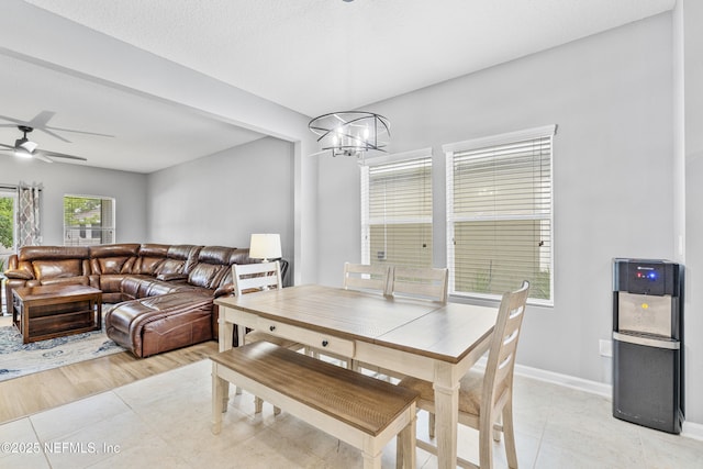 dining room with baseboards, ceiling fan with notable chandelier, and light tile patterned flooring