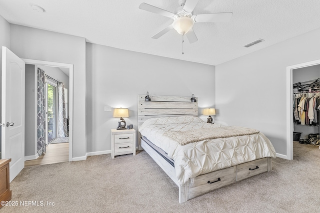bedroom featuring light colored carpet, baseboards, visible vents, and a spacious closet
