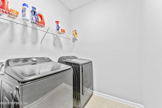 washroom with separate washer and dryer, baseboards, and laundry area