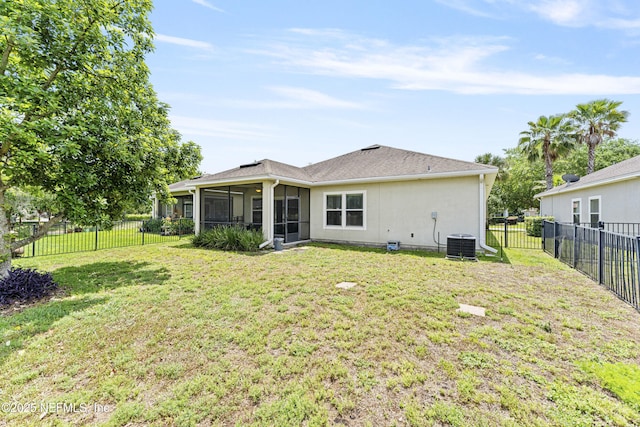 back of property featuring a fenced backyard, a sunroom, a lawn, and cooling unit