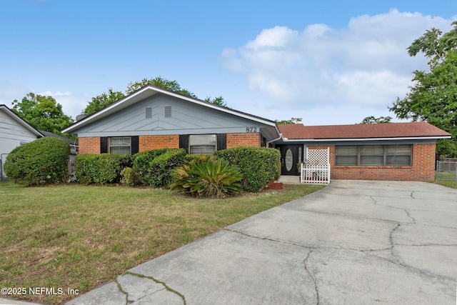 single story home featuring a front yard, driveway, and brick siding