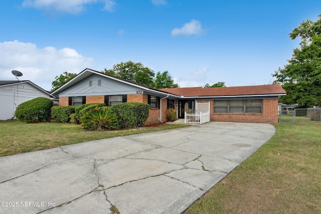 ranch-style house with brick siding, a front lawn, and driveway