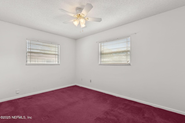carpeted spare room featuring a ceiling fan, baseboards, a wealth of natural light, and a textured ceiling