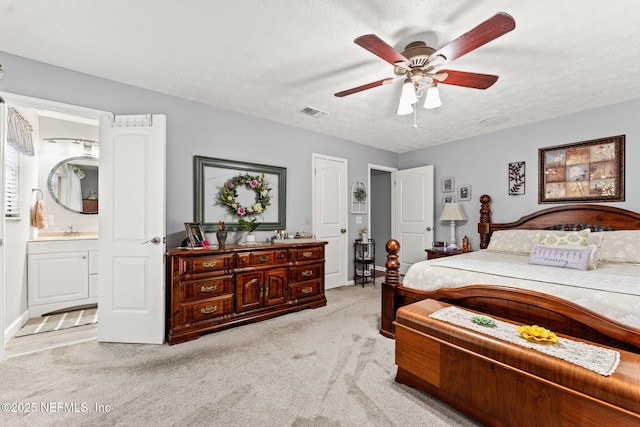 127 Old Jennings Rd, Orange Park, FL 32065 - bedroom with visible vents, ensuite bathroom, light colored carpet, a textured ceiling, and a sink