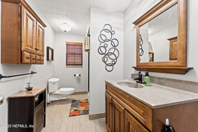 127 Old Jennings Rd, Orange Park, FL 32065 - bathroom featuring vanity, toilet, a textured ceiling, baseboards, and wood finished floors