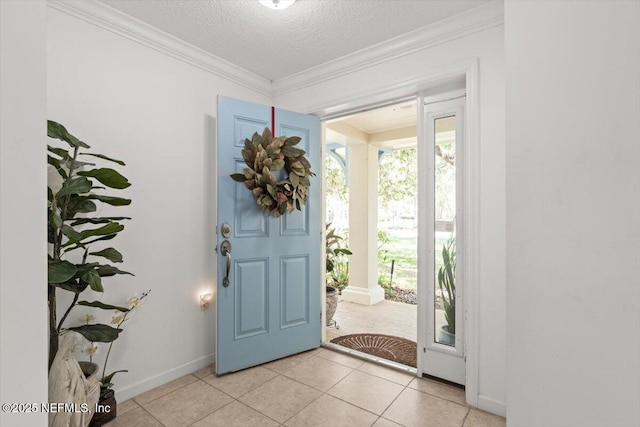 entrance foyer with light tile patterned floors, baseboards, ornamental molding, and a textured ceiling