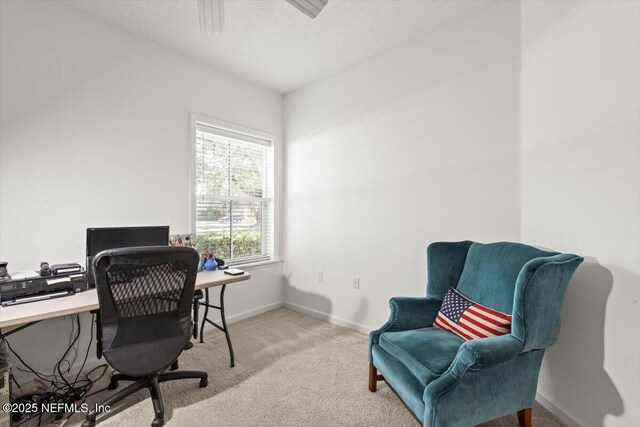 carpeted office space featuring baseboards and ceiling fan