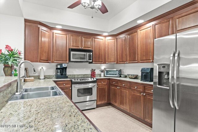 kitchen featuring a ceiling fan, a sink, light countertops, a toaster, and stainless steel appliances