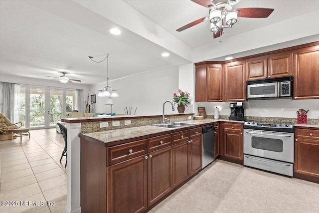 kitchen with a ceiling fan, a sink, a peninsula, open floor plan, and stainless steel appliances