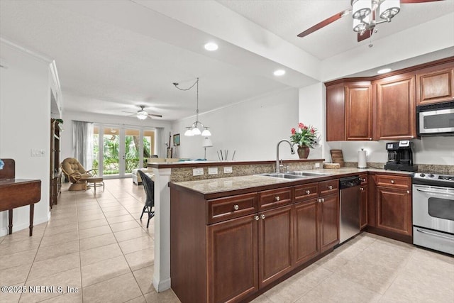 kitchen with a ceiling fan, a sink, appliances with stainless steel finishes, and a peninsula