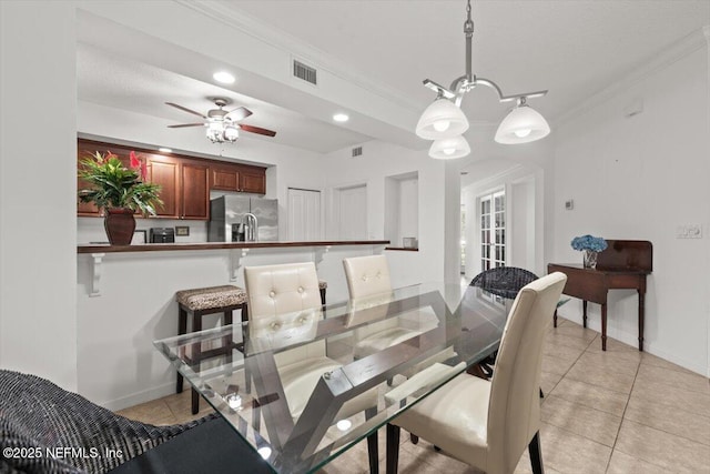 dining area featuring ceiling fan, visible vents, crown molding, baseboards, and light tile patterned flooring
