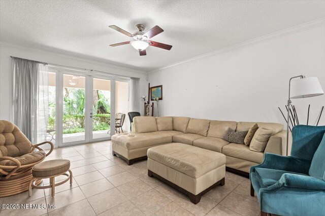 living room with light tile patterned floors, a textured ceiling, ornamental molding, and ceiling fan