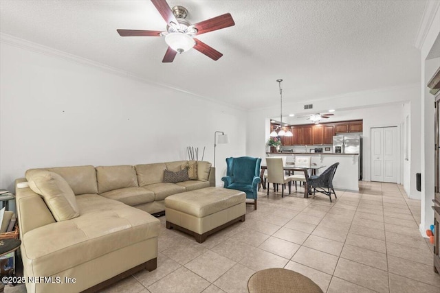 living room featuring crown molding, ceiling fan, visible vents, and light tile patterned floors