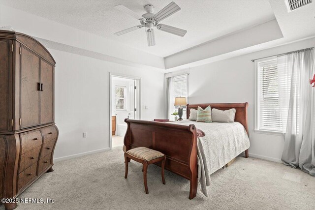 bedroom with visible vents, connected bathroom, baseboards, and light carpet