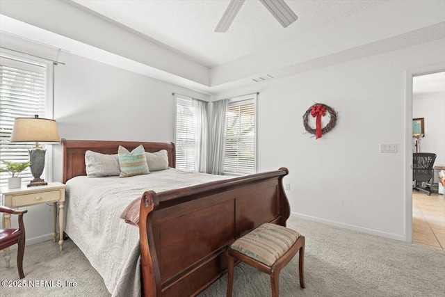 bedroom with a ceiling fan, baseboards, and light colored carpet