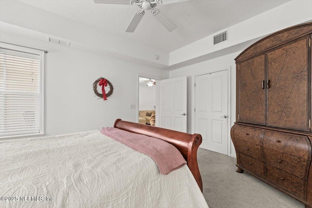 bedroom with a ceiling fan, visible vents, and light carpet