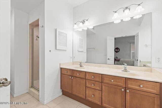ensuite bathroom with ensuite bathroom, a sink, tile patterned flooring, and double vanity