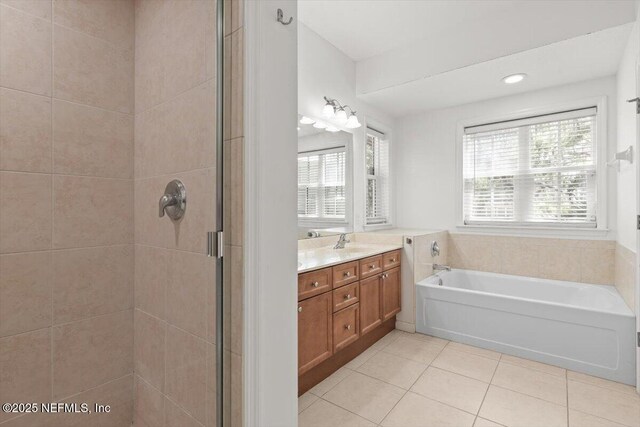 bathroom featuring tile patterned floors, a shower stall, a wealth of natural light, and a garden tub