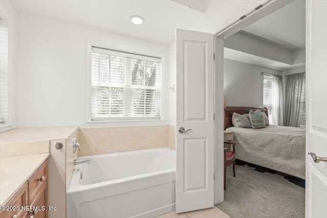 ensuite bathroom featuring ensuite bathroom, a garden tub, and vanity