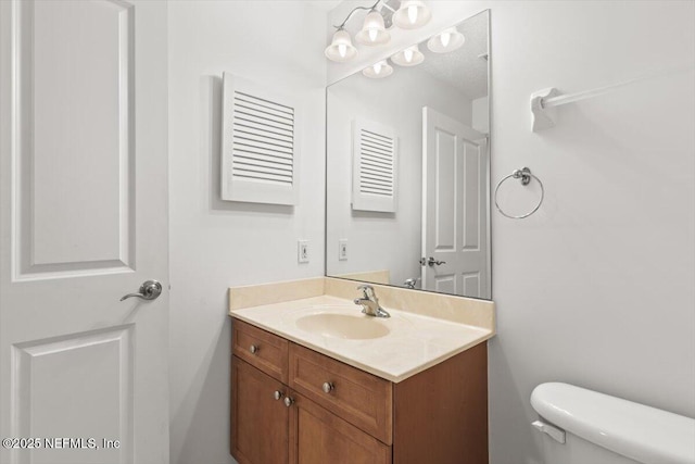 half bathroom with vanity and toilet