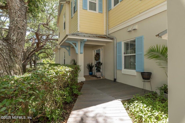doorway to property with stucco siding and a deck