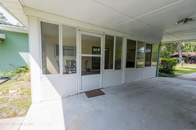 view of exterior entry with a patio area