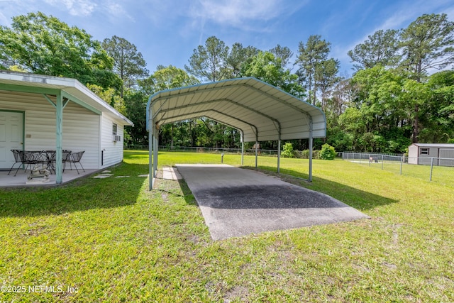 view of parking featuring fence and a detached carport