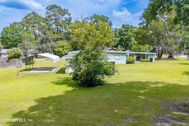 view of yard featuring fence and a detached carport