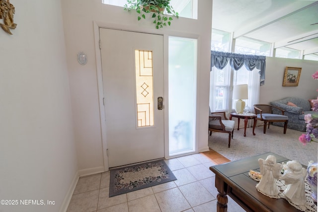 entryway with baseboards and light tile patterned flooring