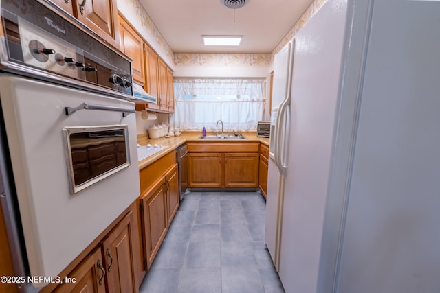kitchen with a sink, tile patterned flooring, white appliances, light countertops, and a toaster
