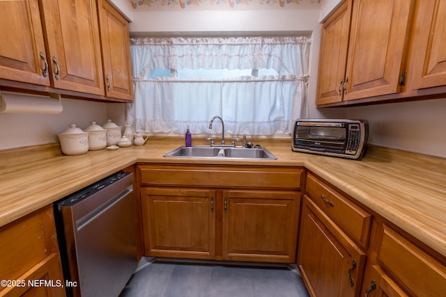 kitchen featuring a sink, light countertops, stainless steel dishwasher, and brown cabinets