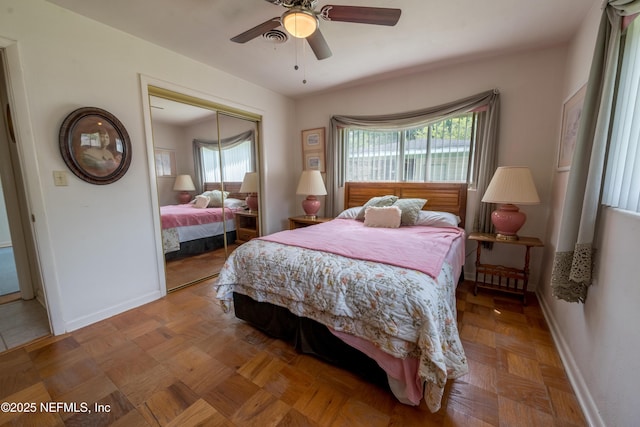 bedroom with a ceiling fan, baseboards, multiple windows, and a closet
