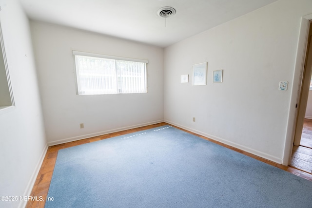 empty room with baseboards and visible vents