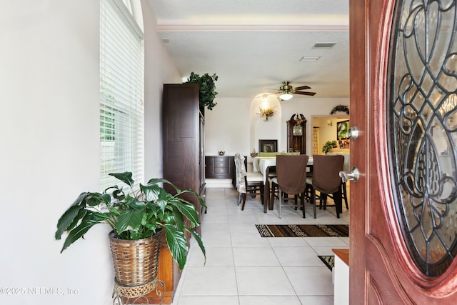 foyer entrance with visible vents, a ceiling fan, and light tile patterned floors