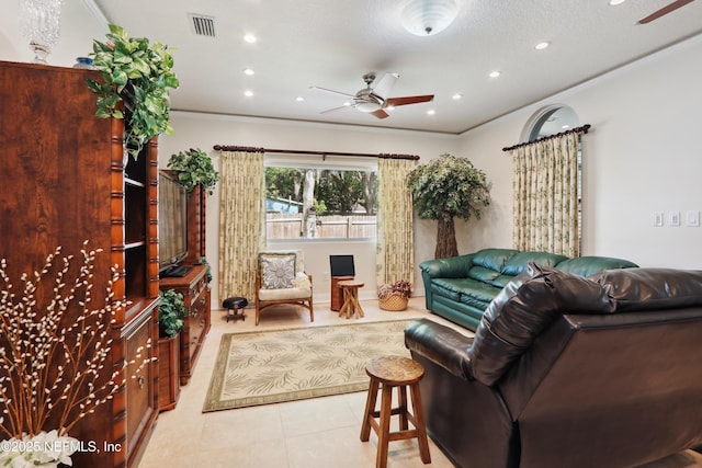 living area featuring crown molding, light tile patterned floors, and ceiling fan