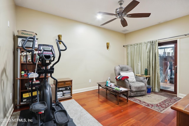 exercise area featuring baseboards, ceiling fan, and wood finished floors