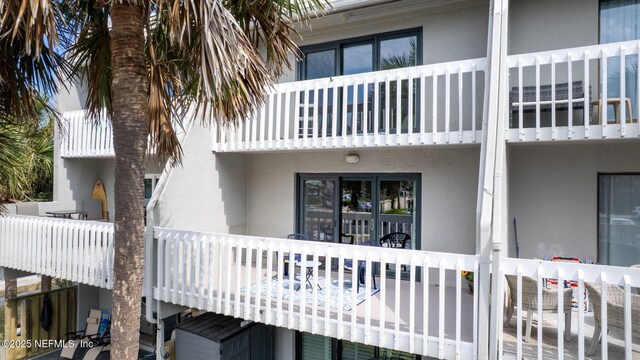 rear view of property featuring stucco siding and a balcony