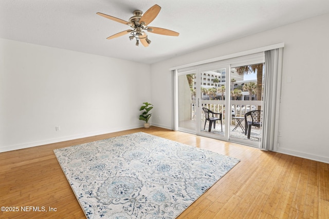 spare room featuring a ceiling fan, wood finished floors, and baseboards