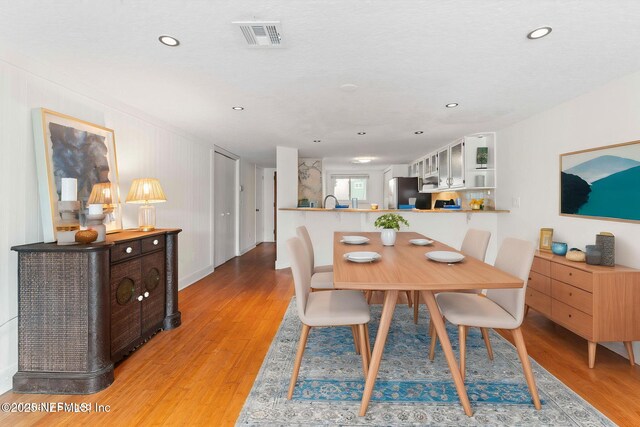 dining space featuring light wood finished floors and recessed lighting
