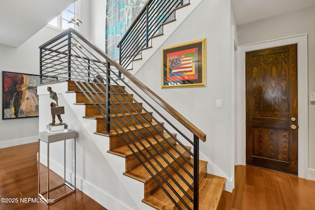 stairway with baseboards and wood finished floors