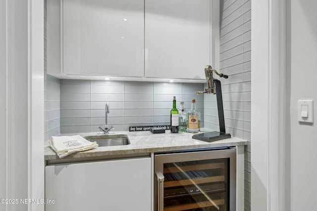bar featuring a sink, tasteful backsplash, indoor bar, and beverage cooler